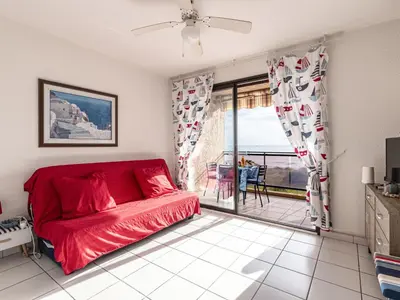 a living room with a red couch and a balcony at Studio Marines de Moriani by Interhome in Moriani Plage