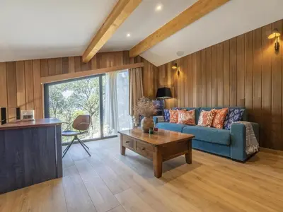 a living room with a blue couch and a table at Chalet Caseddu D'Arasu by Interhome in Sainte-Lucie de Porto-Vecchio