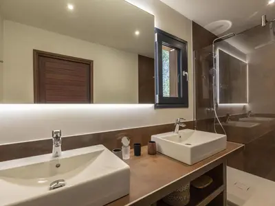a bathroom with two sinks and a mirror at Chalet Caseddu D'Arasu by Interhome in Sainte-Lucie de Porto-Vecchio