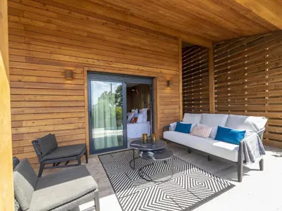 a patio with a couch and a table and chairs at Chalet Caseddu D'Arasu by Interhome in Sainte-Lucie de Porto-Vecchio