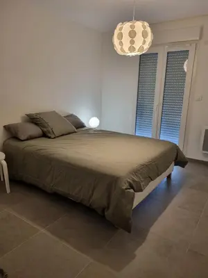 a bedroom with a large bed in a white room at Napoland Appartement T2 recent in Ajaccio