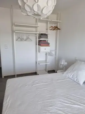 a bedroom with a white bed and a chandelier at Napoland Appartement T2 recent in Ajaccio