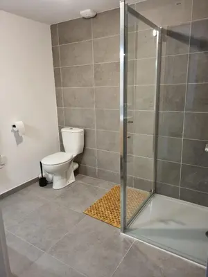 a bathroom with a toilet and a glass shower at Napoland Appartement T2 recent in Ajaccio