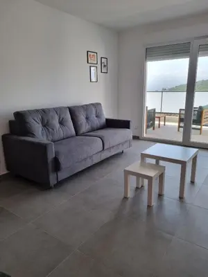 a living room with a couch and a table at Napoland Appartement T2 recent in Ajaccio