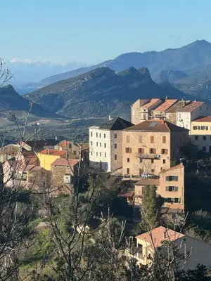 a group of buildings with mountains in the background at Appartement de charme - Nebbiu in Vallecalle