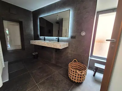 a bathroom with a sink and a mirror and a basket at Appartement de charme - Nebbiu in Vallecalle