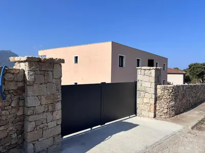 a gate in a stone wall with a house at Appartements neuf, rio este in Viggianello