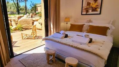a bedroom with a large bed and a sliding glass door at Domaine de Gialla Bergerie Prugna, 6 pers, piscine chauffée, 10 mn plage in Arraggio