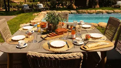 a wooden table with food on it next to a pool at Domaine de Gialla Bergerie Prugna, 6 pers, piscine chauffée, 10 mn plage in Arraggio