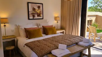 a bedroom with a large bed and a large window at Domaine de Gialla Bergerie Prugna, 2 pers, piscine chauffée, 10 mn plage in Arraggio