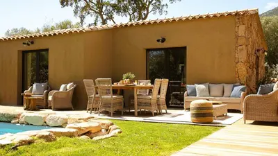 a patio with a table and chairs next to a pool at Domaine de Gialla Bergerie Prugna, 2 pers, piscine chauffée, 10 mn plage in Arraggio
