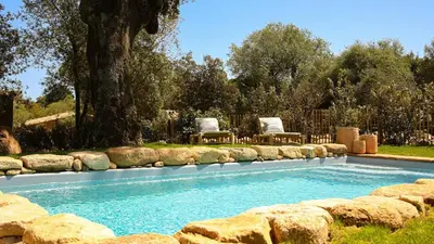 a swimming pool with two chairs in a yard at Domaine de Gialla Bergerie Prugna, 2 pers, piscine chauffée, 10 mn plage in Arraggio
