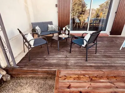 a wooden deck with a table and chairs on it at Villa Cala Longa - Porto Vecchio in Sotta