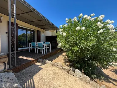 a porch of a house with a table and chairs at Villa Cala Longa - Porto Vecchio in Sotta