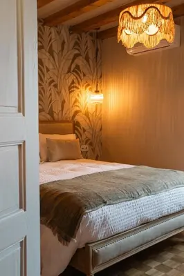 a bedroom with a bed and a chandelier at Torra di l alba in Viggianello