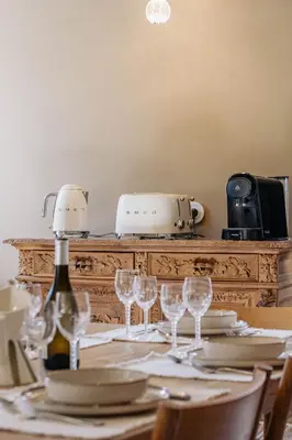 a table with glasses and a bottle of wine at Torra di l alba in Viggianello