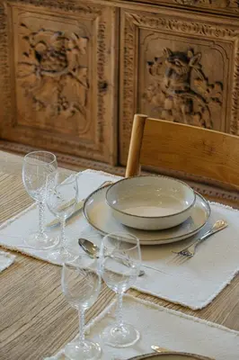 a table with a plate and wine glasses on it at Torra di l alba in Viggianello