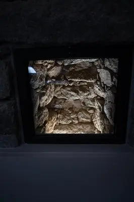 a stone wall with a fireplace in a room at Torra di l alba in Viggianello