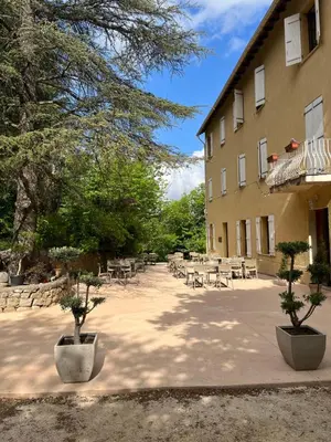 a courtyard with tables and chairs next to a building at Beau Séjour in Bocognano
