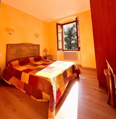 a bedroom with a bed and a window at Beau Séjour in Bocognano