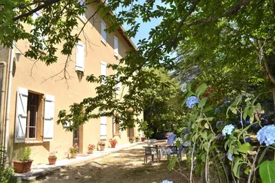 a courtyard of a house with a table and chairs at Beau Séjour in Bocognano