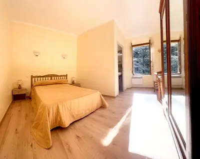 a bedroom with a bed and a wooden floor at Beau Séjour in Bocognano