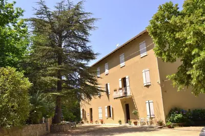 a large brick building with a tree in front of it at Beau Séjour in Bocognano