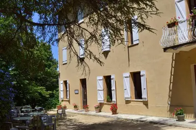a building with tables and chairs in front of it at Beau Séjour in Bocognano