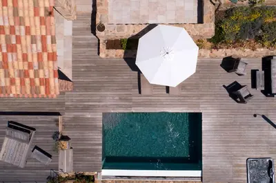 an overhead view of a pool with a white umbrella at Les Bergeries d'Arone in Piana
