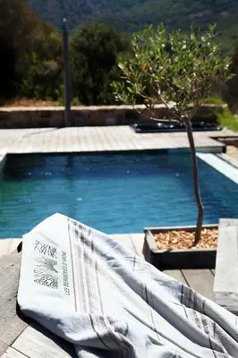 a towel sitting on a table next to a swimming pool at Les Bergeries d'Arone in Piana