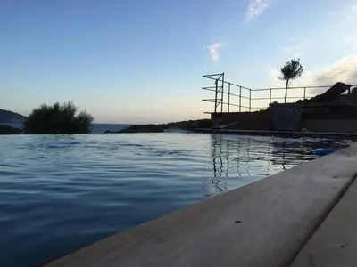 a swimming pool with the ocean in the background at Les Bergeries d'Arone in Piana