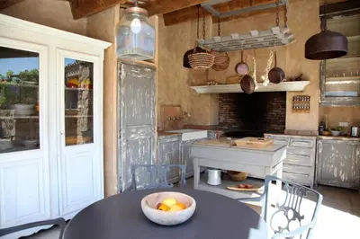 a kitchen with a table with a bowl of fruit on it at Les Bergeries d'Arone in Piana