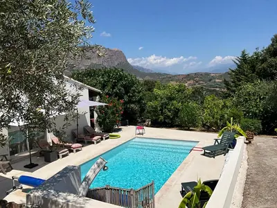 a swimming pool in a backyard with mountains in the background at Chambre Studio chez l habitant in Alata