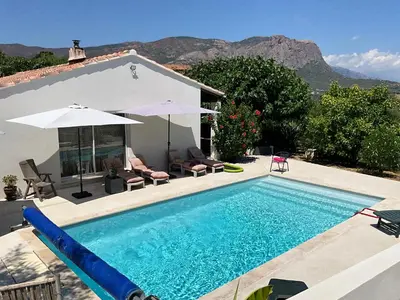 a swimming pool in front of a house at Chambre Studio chez l habitant in Alata