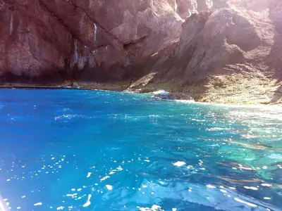 a large body of blue water next to a mountain at Chambre Studio chez l habitant in Alata
