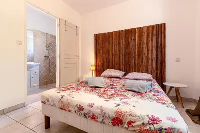 a bedroom with a large bed with a wooden headboard at Casa Bavitoli 1er étage - Avec jardin et terrasse in Cauro