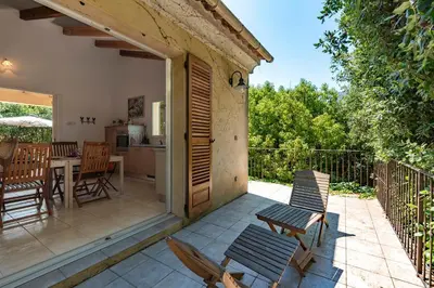 a patio with chairs and a table and a kitchen at Casa Bavitoli 1er étage - Avec jardin et terrasse in Cauro