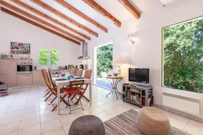 a living room with a table and chairs and a tv at Casa Bavitoli 1er étage - Avec jardin et terrasse in Cauro