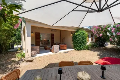 a patio with a table and an umbrella at Casa Bavitoli 1er étage - Avec jardin et terrasse in Cauro