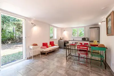 a living room with a table and a kitchen at Casa Bavitoli RDC - Avec jardin in Cauro