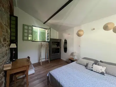 a bedroom with a bed and a desk in it at To a Book House in Corsica - chambres d'hôtes in Oletta