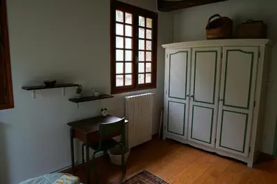 a room with a cabinet and a table and a window at To a Book House in Corsica - chambres d'hôtes in Oletta