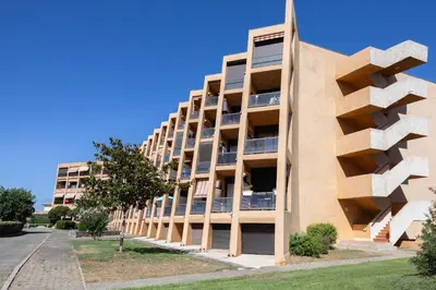 an apartment building with balconies on a street at Casa Santa Lucia - Climatisé au bord de Mer in Santa-Lucia-di-Moriani