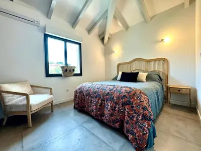 a bedroom with a bed and a chair and a window at A Casa Catalina - Charming villa in Afa