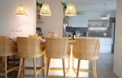 a kitchen with a table with rattan bar stools at A Casa Catalina - Charming villa in Afa