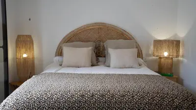 a bedroom with a large bed with two lamps at A Casa Catalina - Charming villa in Afa