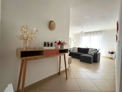 a living room with a table and a couch at MORIANI Centre Lumineux T3 à deux pas de la mer et commerces in Moriani Plage