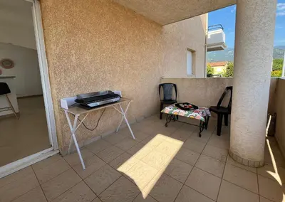 a room with a table and chairs on a balcony at MORIANI Centre Lumineux T3 à deux pas de la mer et commerces in Moriani Plage