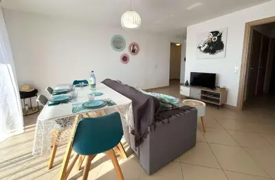 a living room with a couch and a table with chairs at MORIANI Centre Lumineux T3 à deux pas de la mer et commerces in Moriani Plage