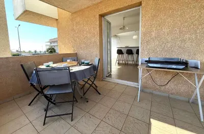 a dining room with a table and chairs and a window at MORIANI Centre Lumineux T3 à deux pas de la mer et commerces in Moriani Plage